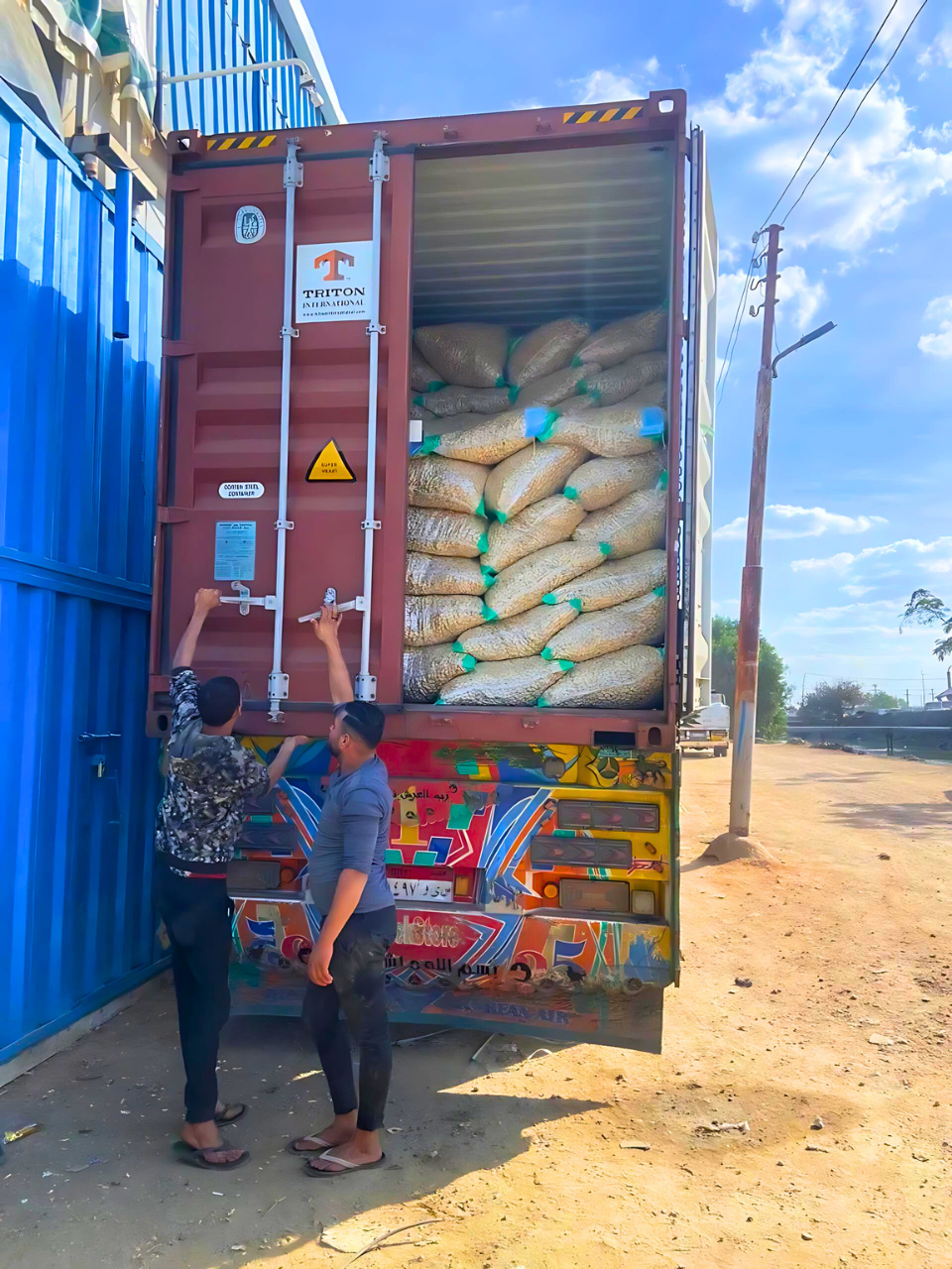 Crops Workers load sacks into a Triton International shipping container on a truck. Exporter